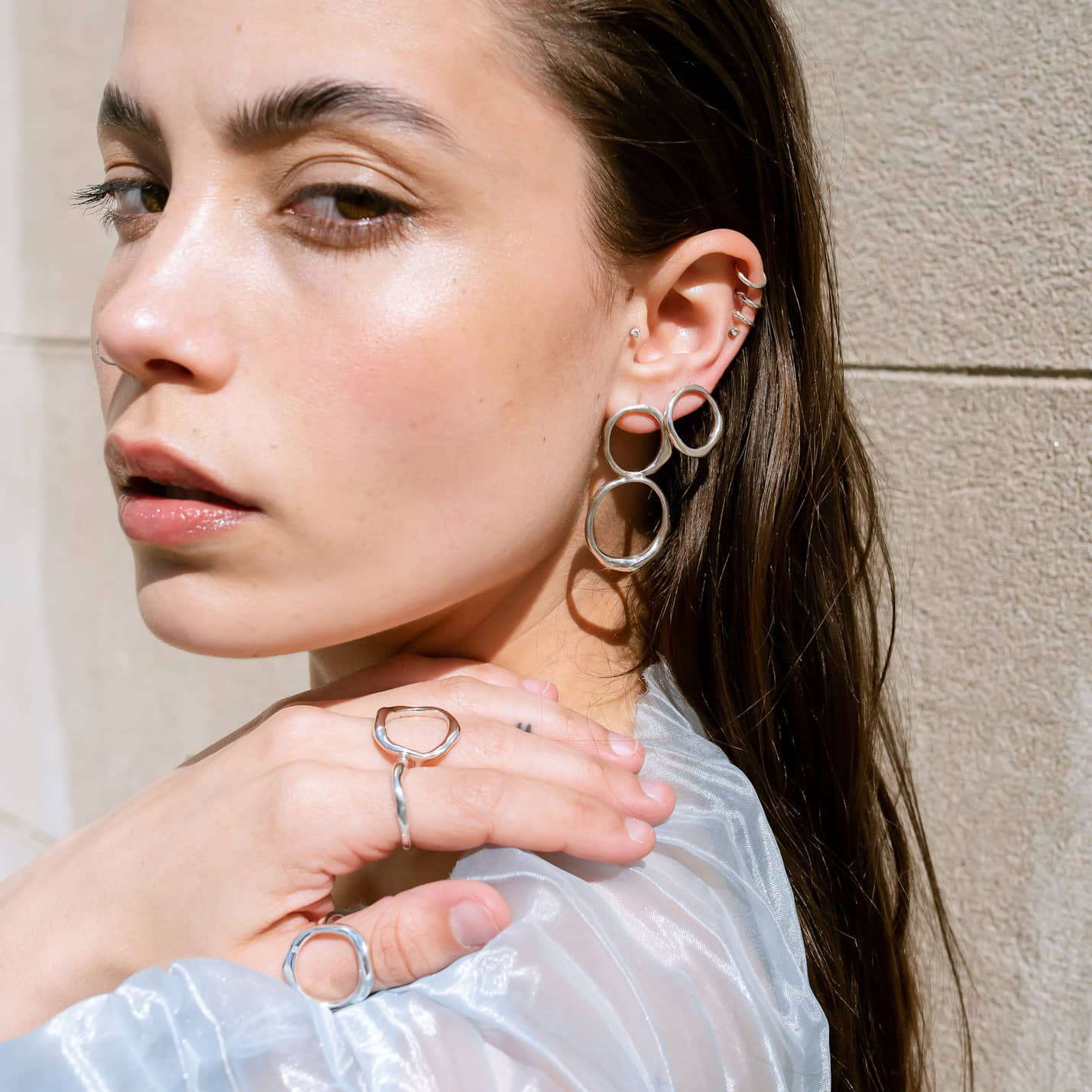 Curves Big Clean silver earrings on model.