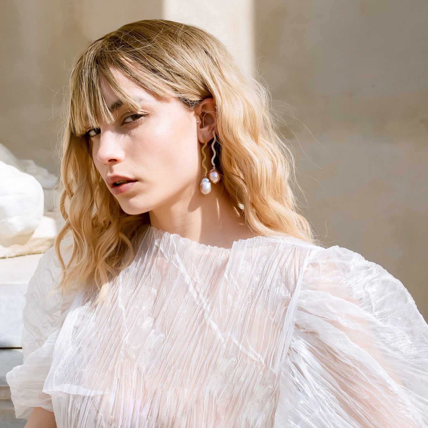 Shape Baroque Big gold plated pearl earrings on model.
