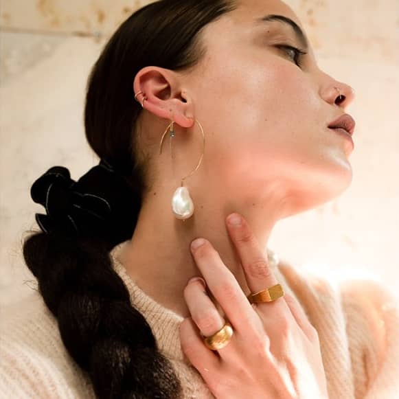 Simple Baroque 14 kt gold earrings on model.
