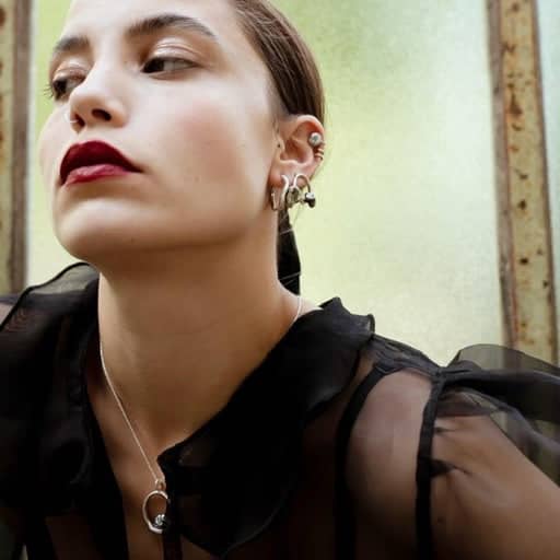 Curves Collection small silver earrings on model.