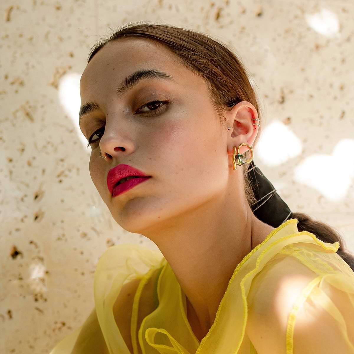 Curves gold plated earrings on model.