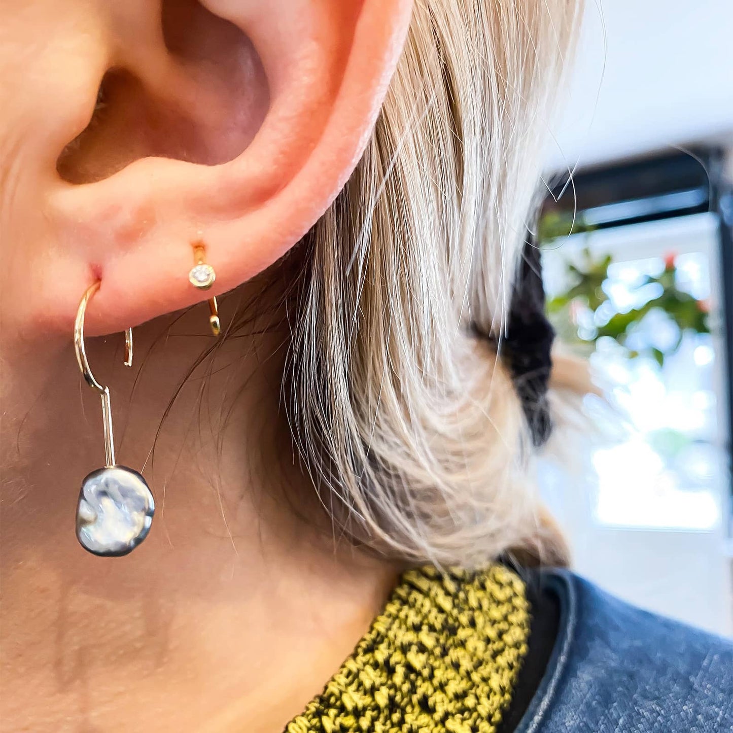 Simple Keshi Small 14 kt gold earring on model.