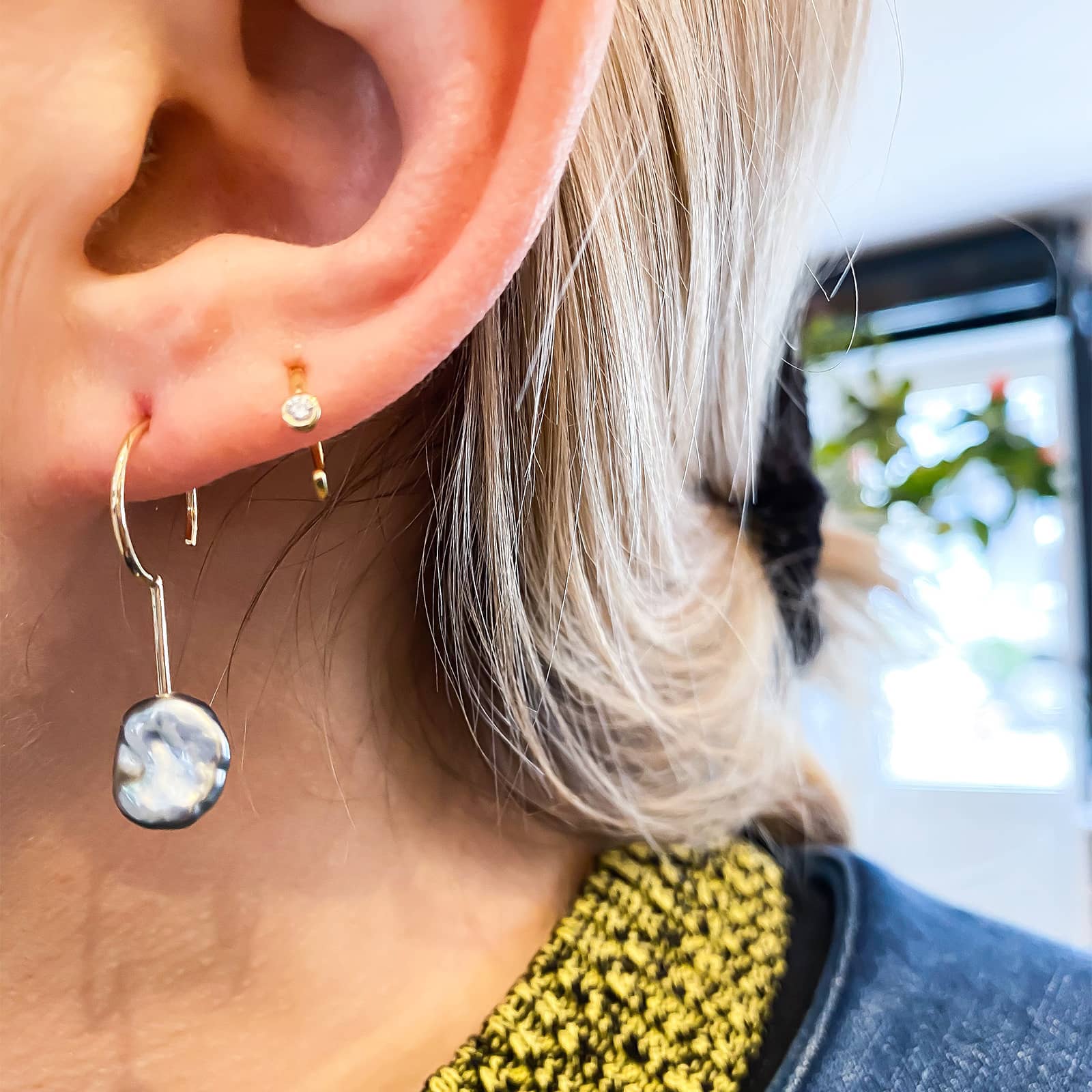 Simple Keshi Small 14 kt gold earring on model.